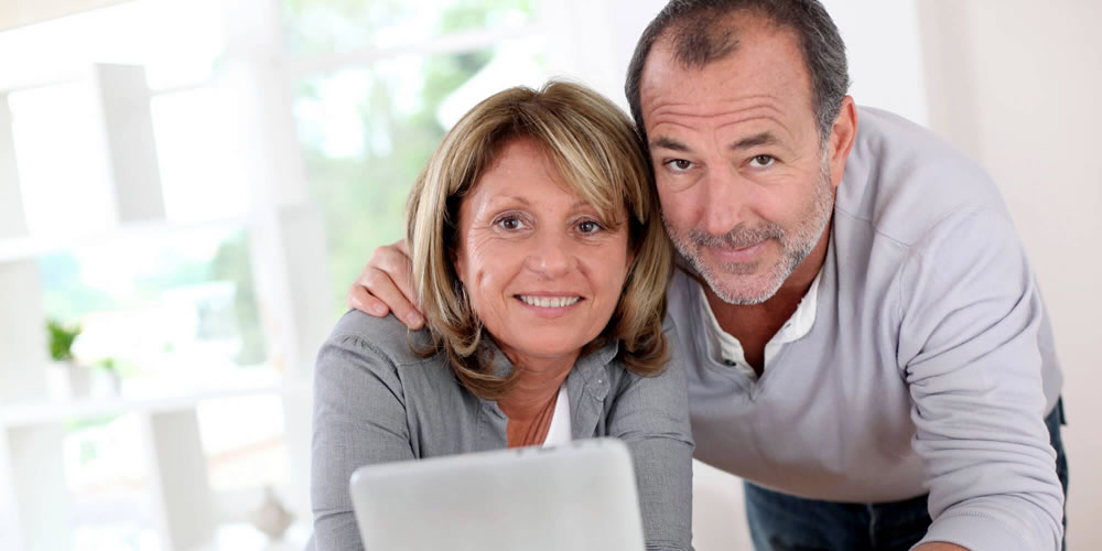 a young couple on the sofa with laptops